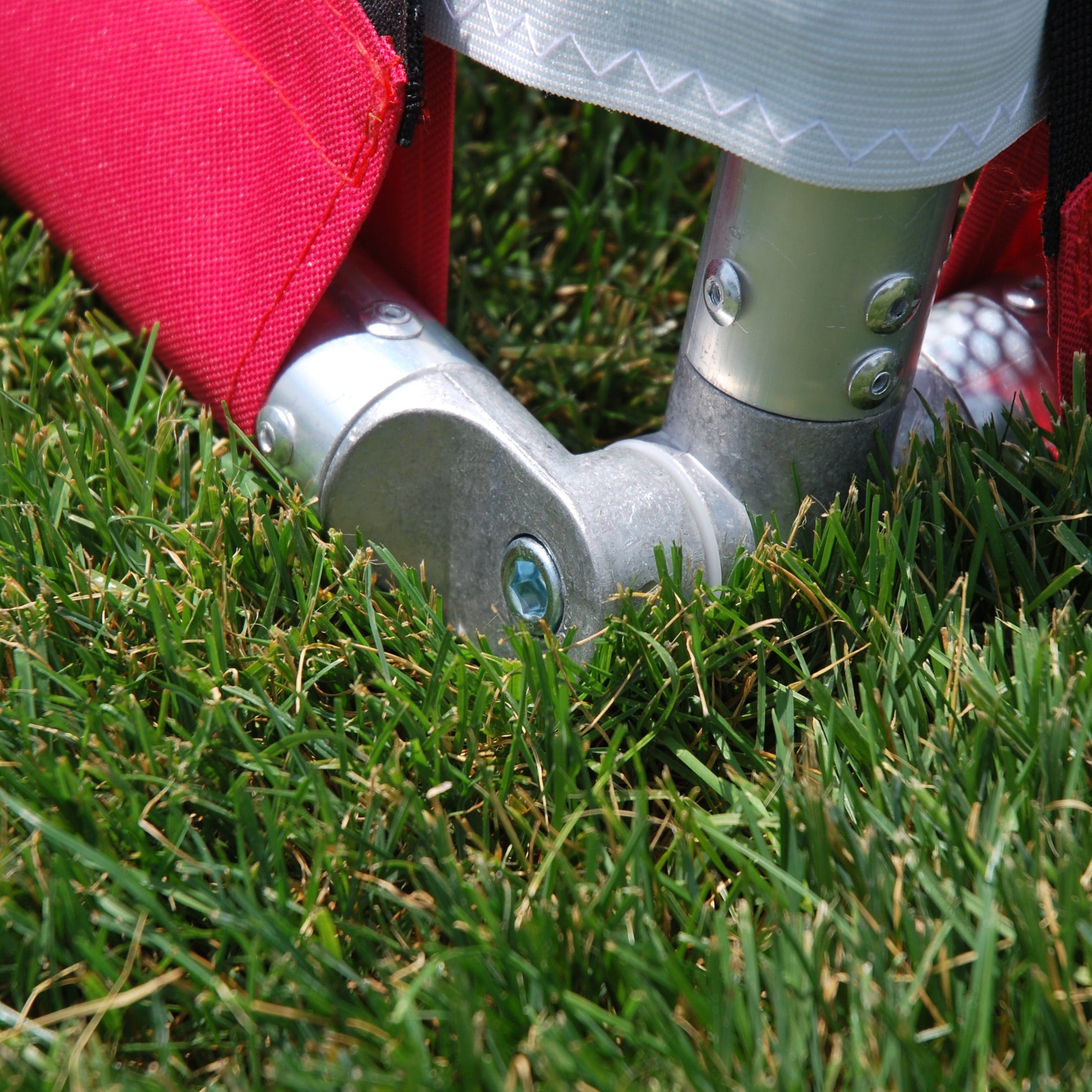 Close-up of aluminum base bar and lower corner joint on red soccer goal frame