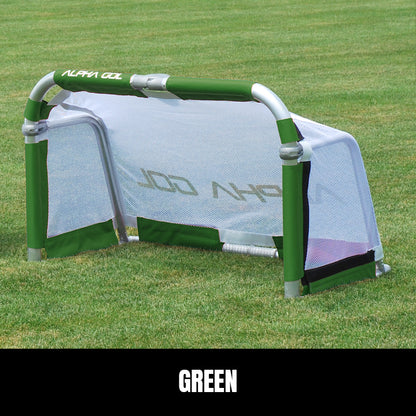 Green folding soccer goal on grass, front view, silver aluminum frame with white mesh netting
