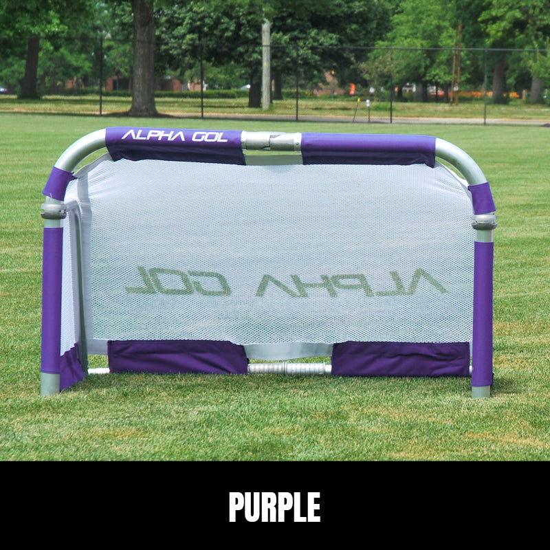 Purple folding soccer goal on grass, front view, silver aluminum frame with white mesh netting