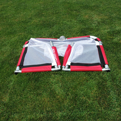 Red folding soccer goal laid flat on grass, showing 5.5 inch closed profile