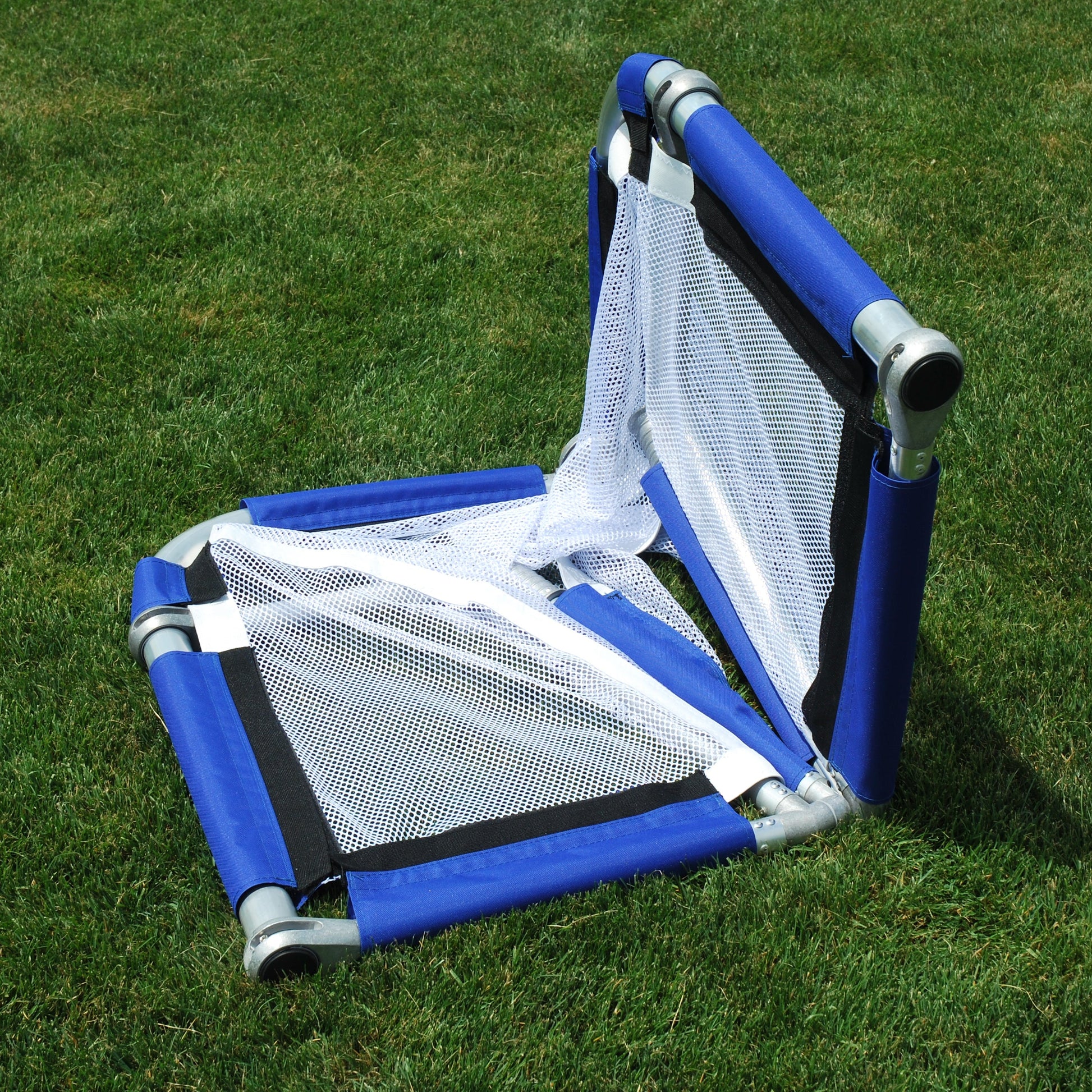 Royal folded soccer goal upright on grass, folded view, silver aluminum frame with white mesh netting