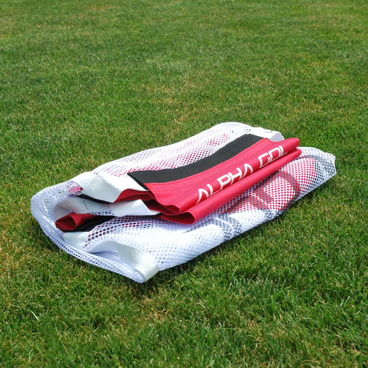 Folded white mesh net soccer goal netting on green grass