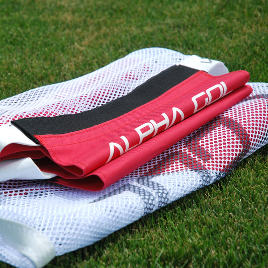 White mesh soccer net folded up on green grass lawn